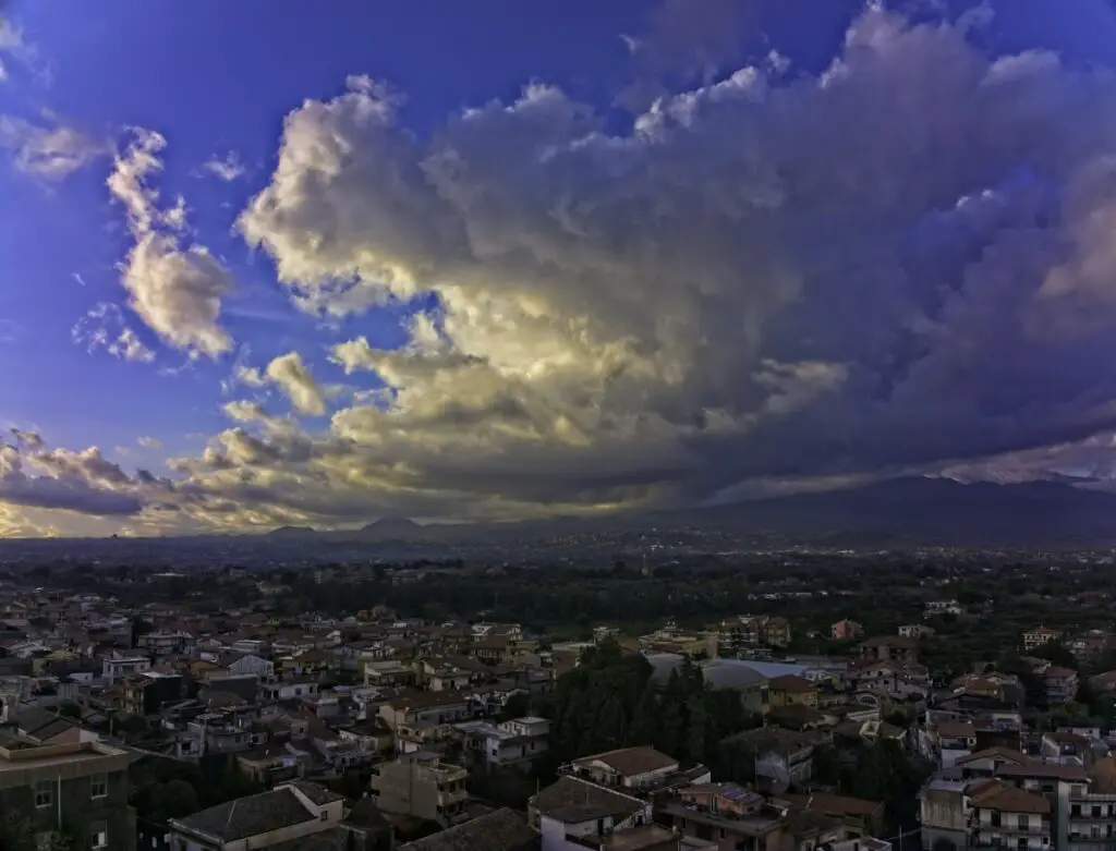 A village in Sicily with Mount Etna and clouds reflecting the sun. Photo taken with a DJI Mavic 3 by Vicvideopic