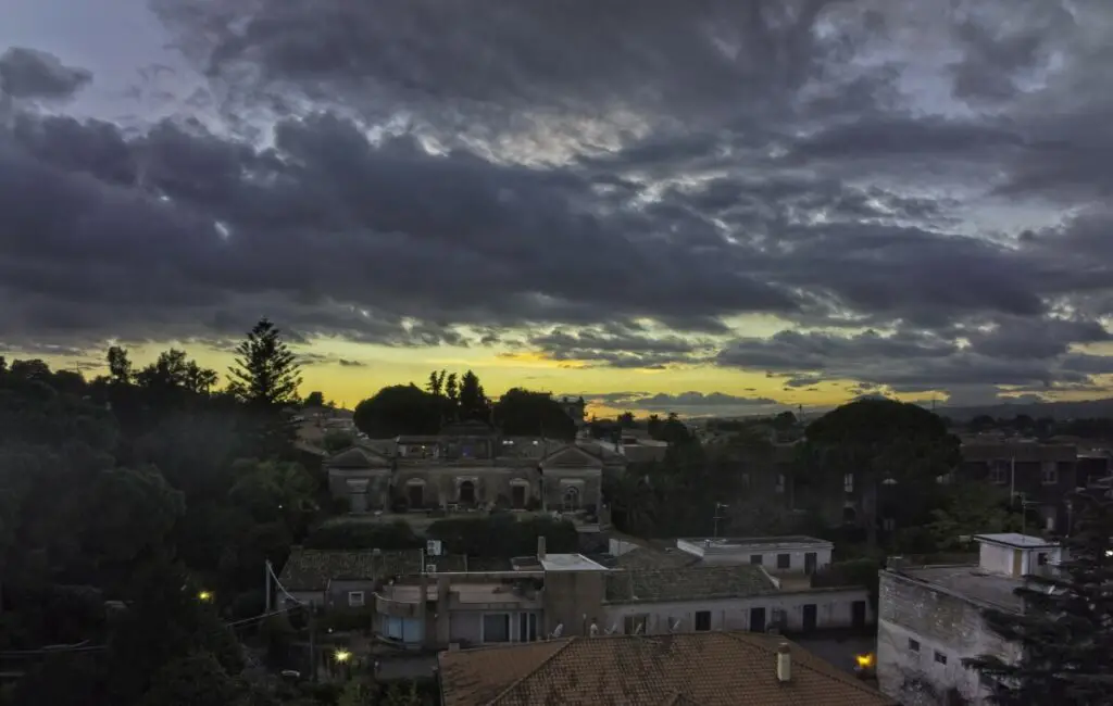 A village in Sicily at sunset against the sun with clouds. Photo taken with a DJI Mavic 3 by Vicvideopic